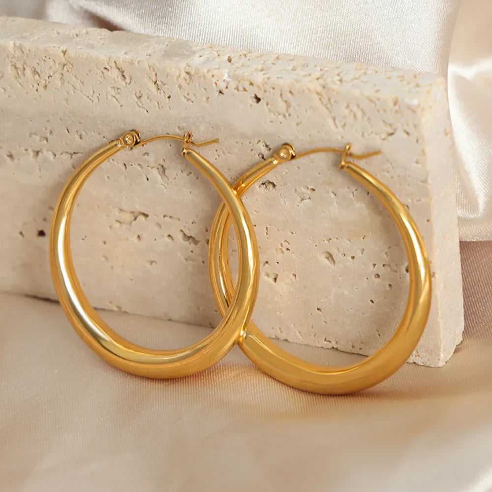 Sculpted oval gold hoop earrings, 18K gold-plated, polished finish.