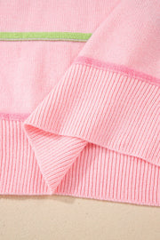Blush pink knit henley sweater with pastel green stripe detail and ribbed cuffs.