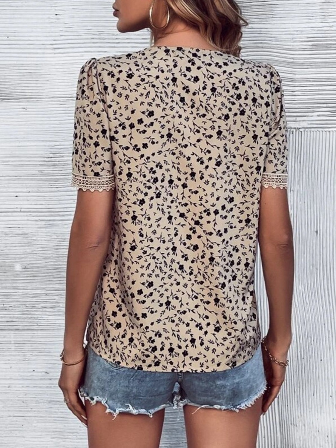 Tan floral print blouse with V-neck and lace trim on short sleeves.