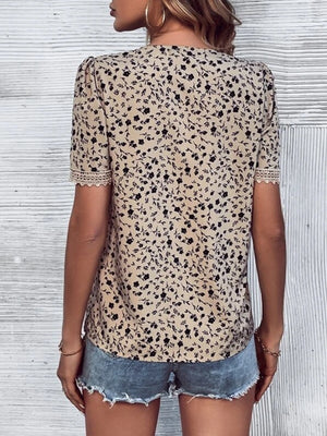 Tan floral print blouse with V-neck and lace trim on short sleeves.
