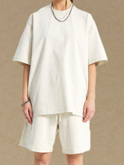 Boxy cut white t-shirt with crew neck and short sleeves, styled with matching shorts.