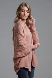 Pink acrylic batwing cardigan with textured knit and wide sleeves.