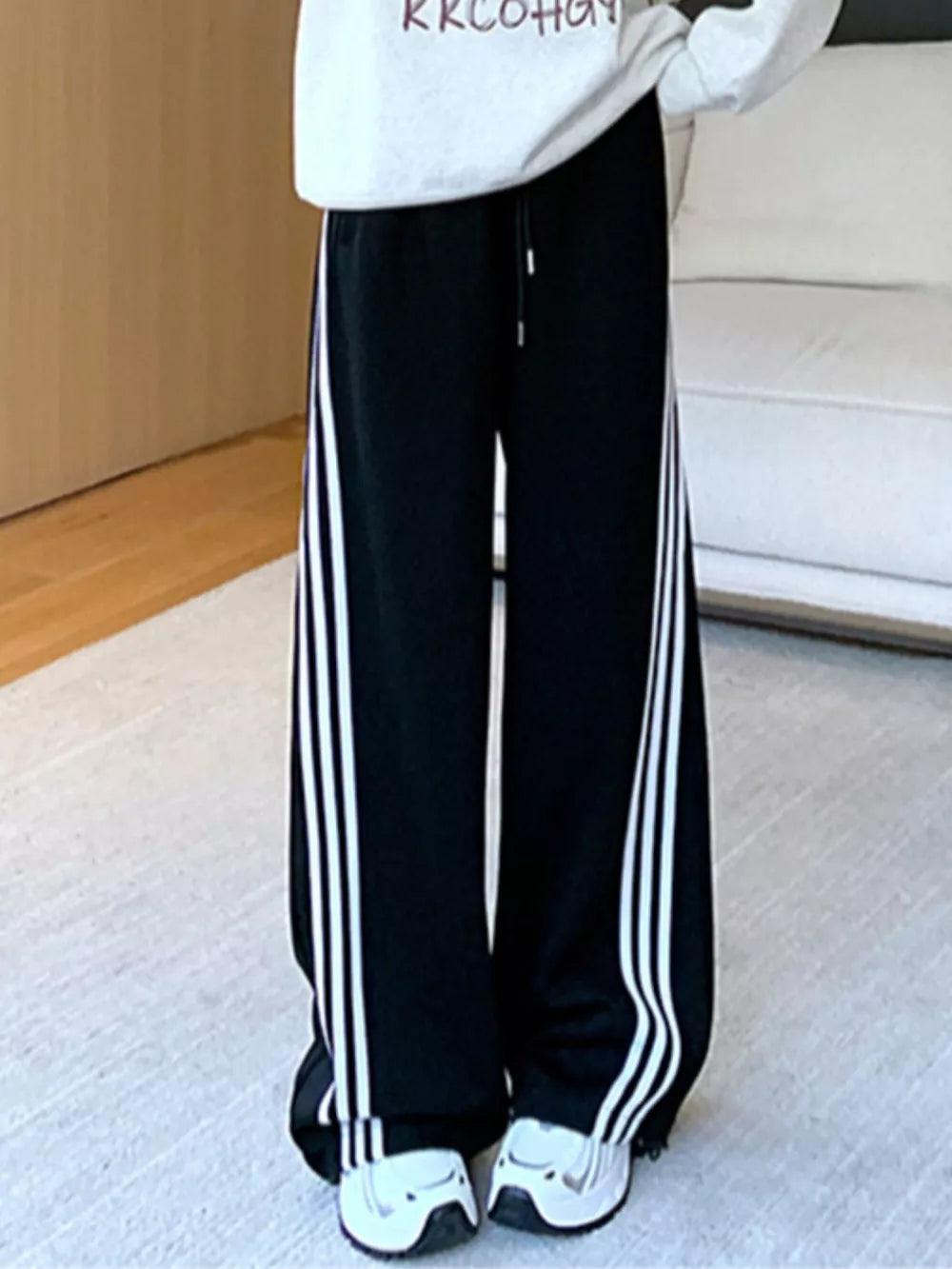 Black wide-leg maternity joggers with white side stripes and drawstring waist.