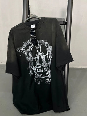 Black distressed graphic tee with skull print and ripped details.