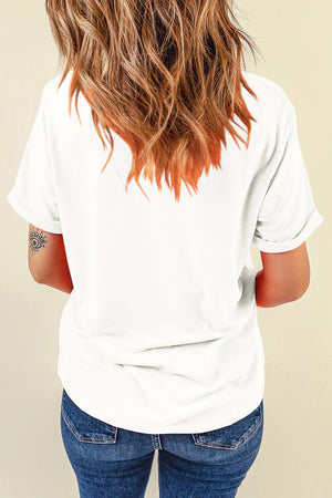 White graphic t-shirt with rolled sleeves and a small eye tattoo on the arm.