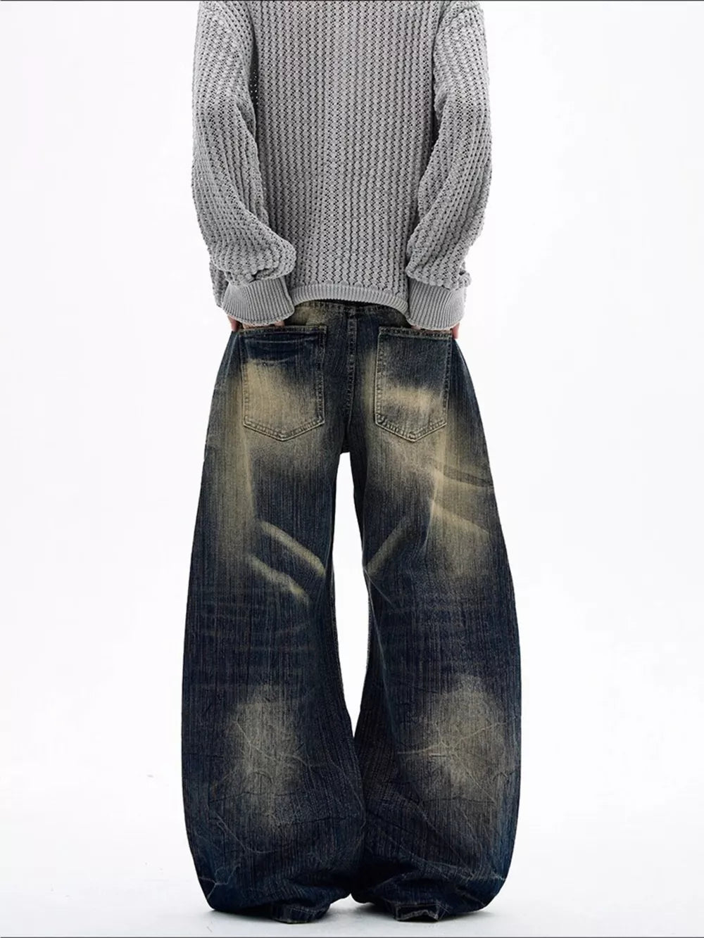 Men's vintage wash wide leg jeans in dark blue denim with distressed details.