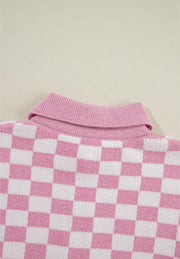 Pink checkerboard knit polo sweater with ribbed collar.