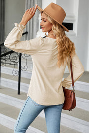 Textured cream puff sleeve blouse with ruffle cuffs and a square neckline.