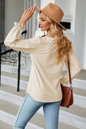 Textured cream puff sleeve blouse with ruffle cuffs and a square neckline.