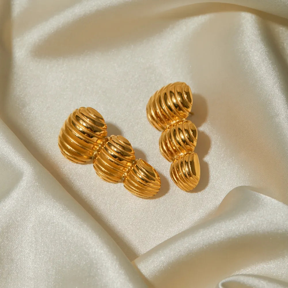 Gold drop earrings with sculptural spiral design, 18K gold-plated.
