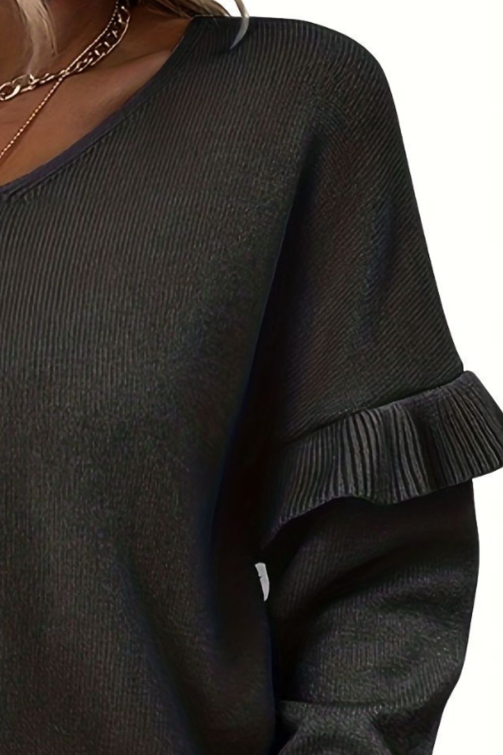 Black knit v-neck pullover sweater with ruffled sleeve detail.