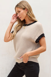 Beige knit cap sleeve sweater with black trim detail.