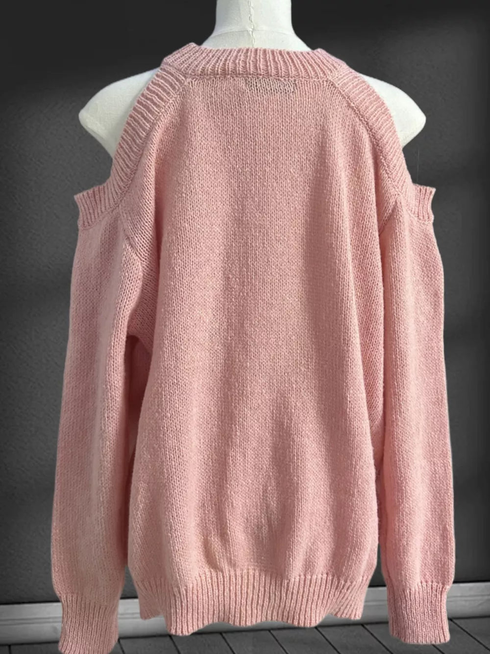 Pink cold shoulder knit sweater with crew neck and ribbed cuffs and hem.