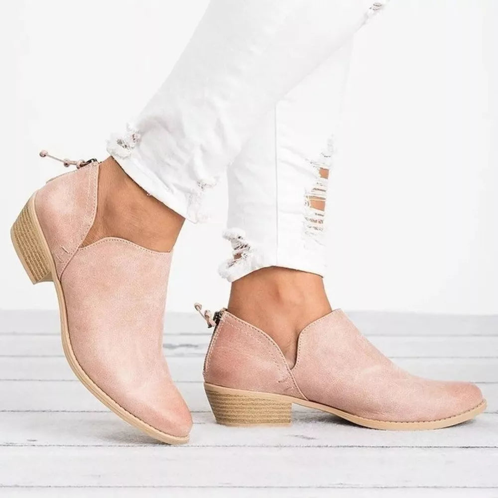 Pink V-cut pointed toe block heel boots with a side zipper detail.