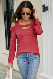 Red sweater with cold shoulder cutouts and a keyhole neckline detail.