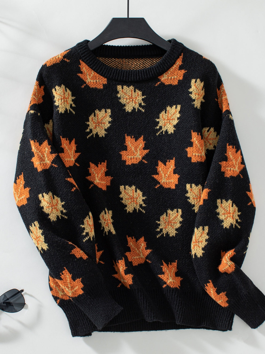 Black knit jumper with autumnal leaf motif, crew neck, long sleeves.