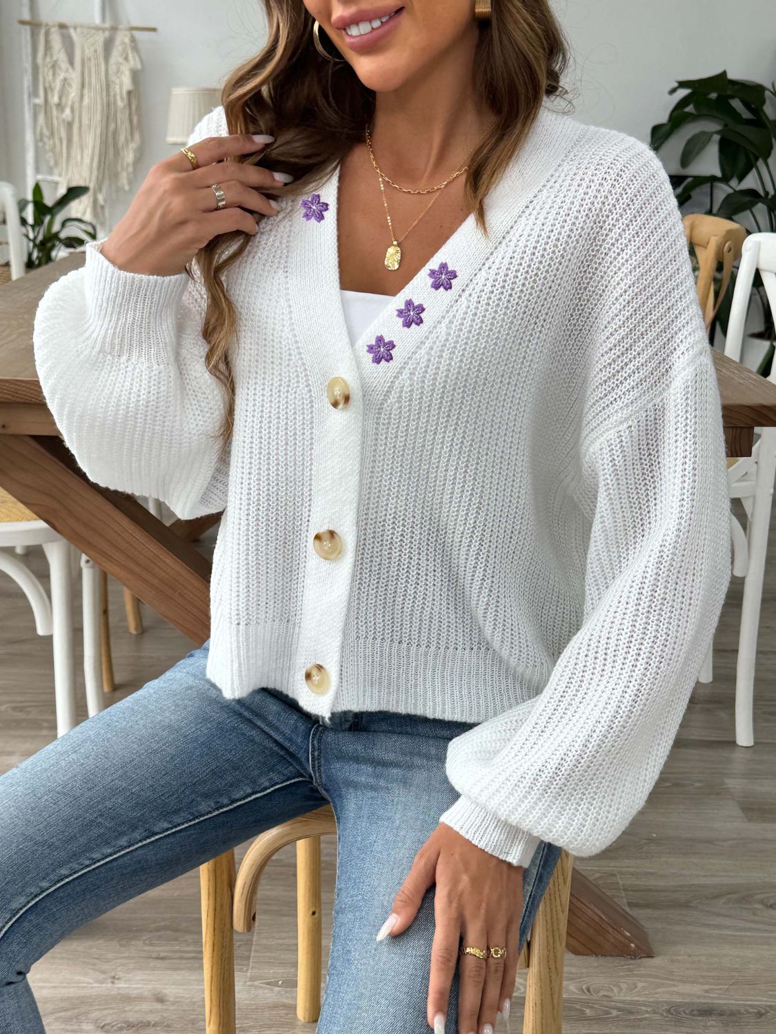 White balloon sleeve cardigan with floral embellishments and button front.