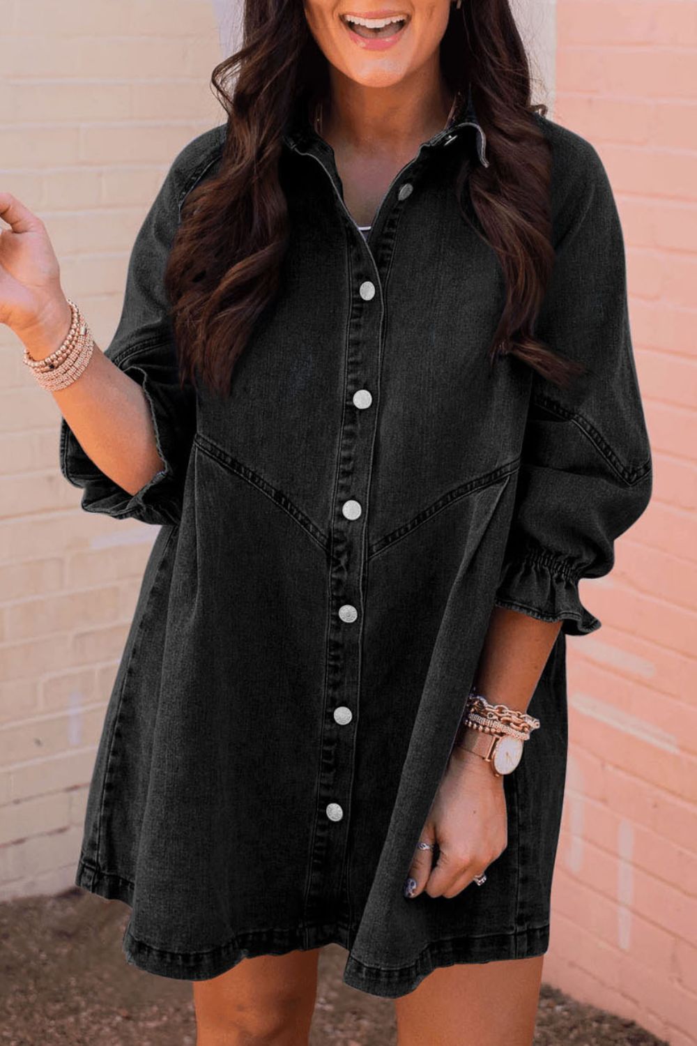 Black denim shirtdress with button front and ruffled cuff detail.