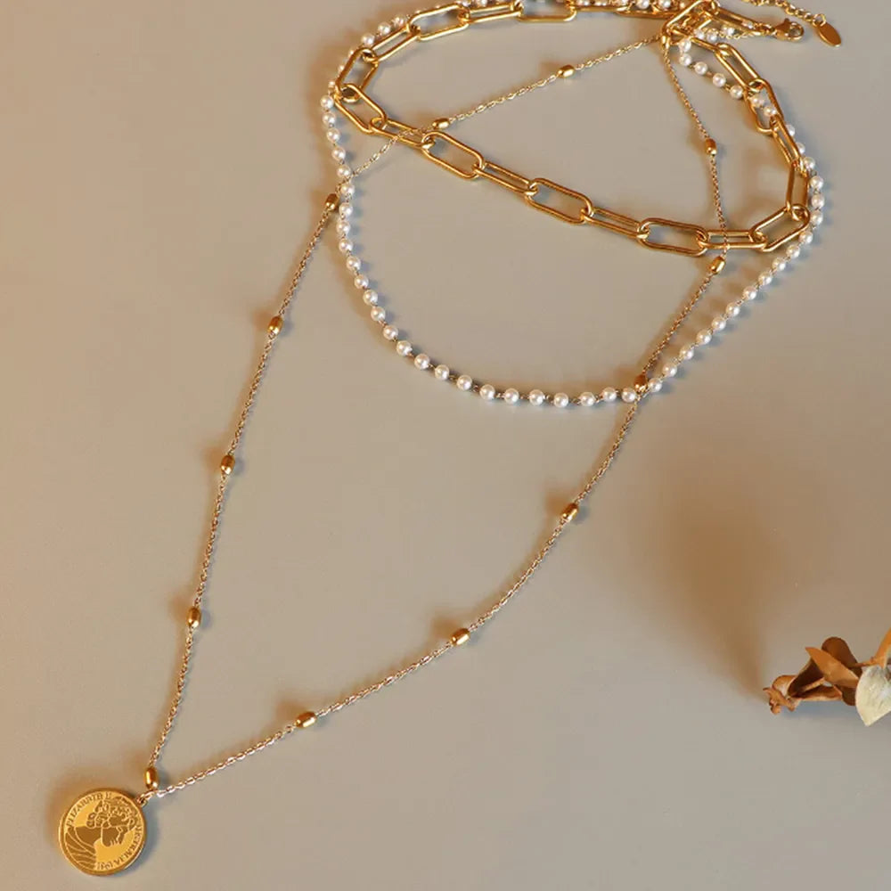 Gold layered necklace with chain, pearls, and coin pendant