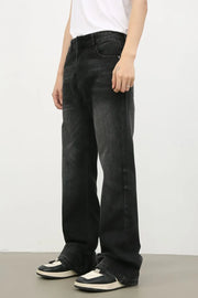 Dark wash denim trousers with exaggerated flare, styled with sneakers.
