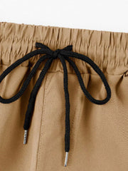 Khaki cargo pants with adjustable drawstring waist and metal-tipped cords.