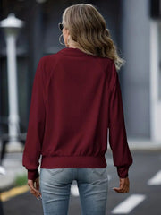 Burgundy textured ribbed raglan zip-up jacket with a mock neck and elastic cuffs.