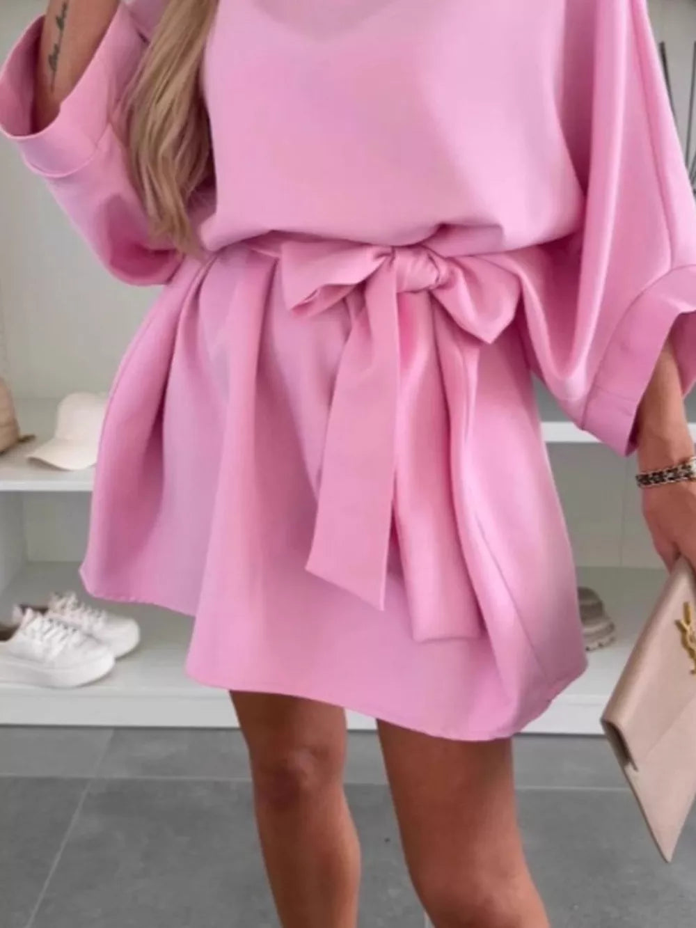 Pink batwing sleeve mini dress with tie waist and flared skirt.