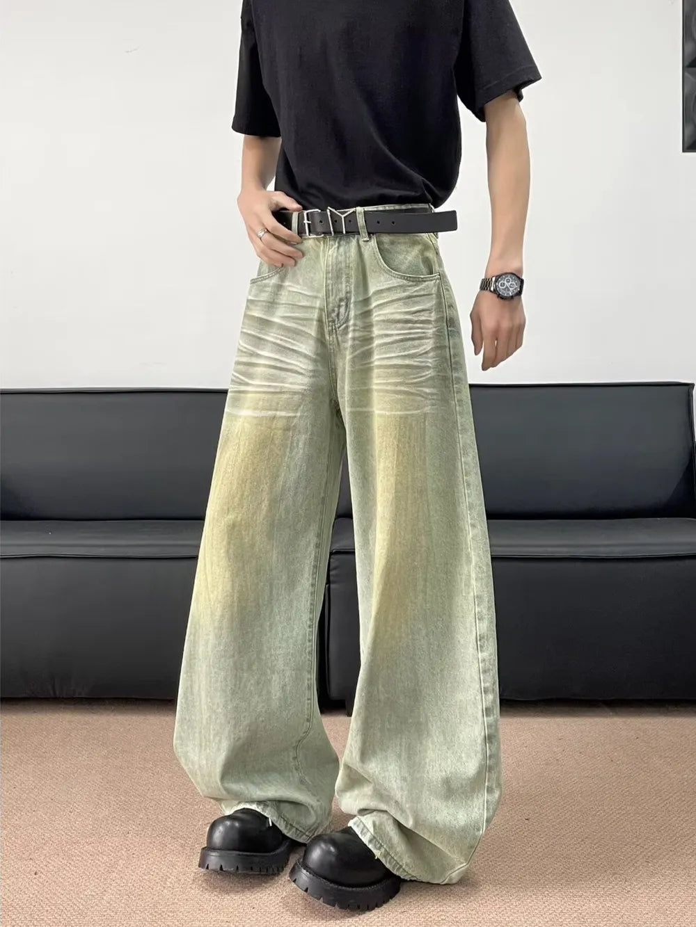 Men's oversized jeans in a light green wash with creasing detail and a relaxed fit.