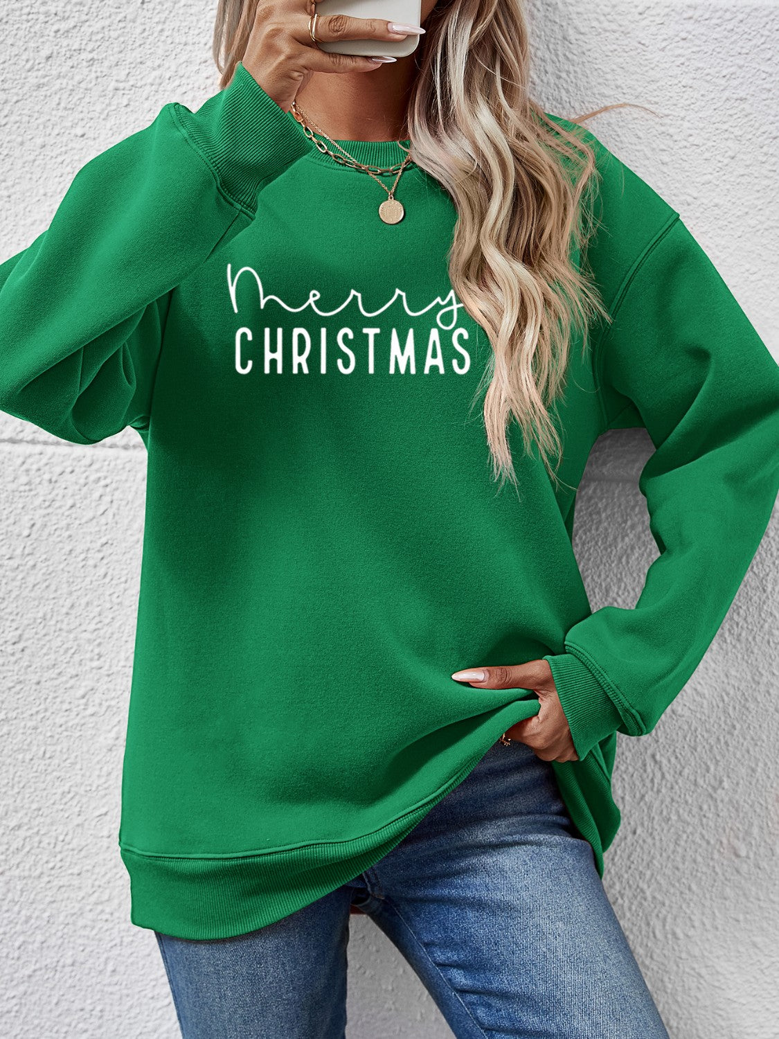 Green Merry Christmas graphic sweatshirt with crew neck and long sleeves.