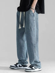 Men's light blue loose fit jeans with drawstring waist and casual styling.