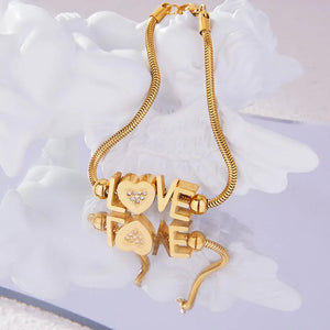 Gold snake chain bracelet with "LOVE" letter charms and a heart charm with rhinestones.