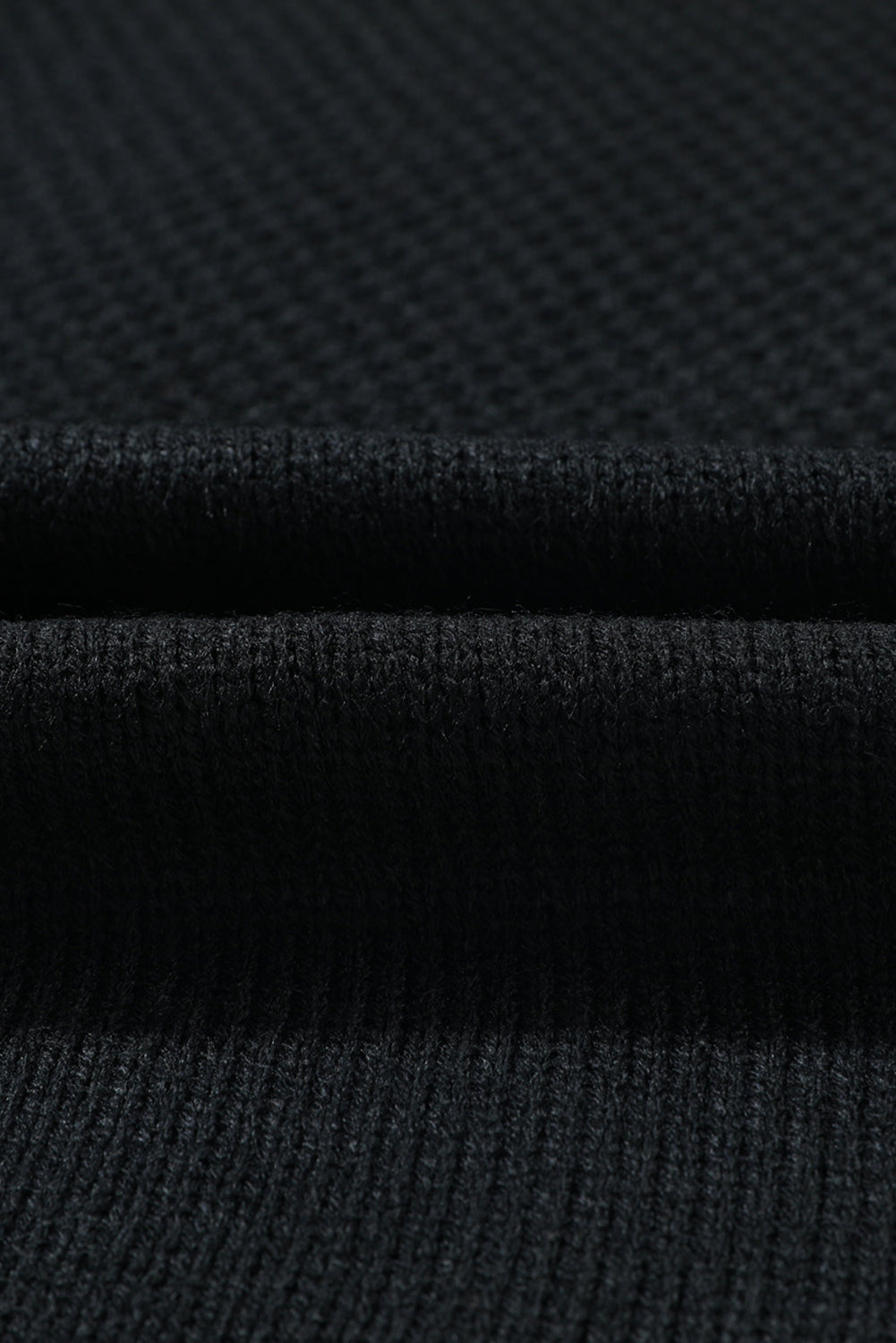 Black acrylic knit cardigan showing ribbed texture and fabric detail
