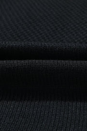 Black acrylic knit cardigan showing ribbed texture and fabric detail
