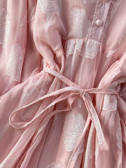 Pink chiffon maxi dress with floral embroidery and a belted waist.