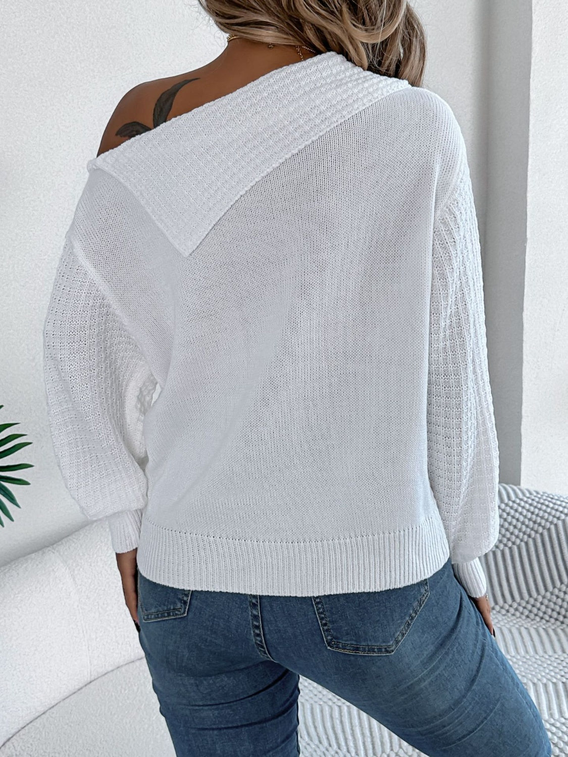 White off-shoulder cable knit pullover sweater with textured sleeves.