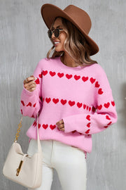Pink knit pullover sweater with red heart stripes, crew neck, long sleeves.