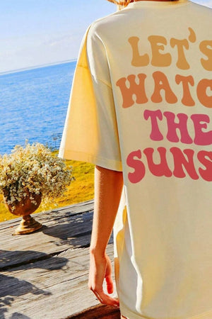 Oversized khaki t-shirt with retro "Let's Watch The Suns" graphic print on back.