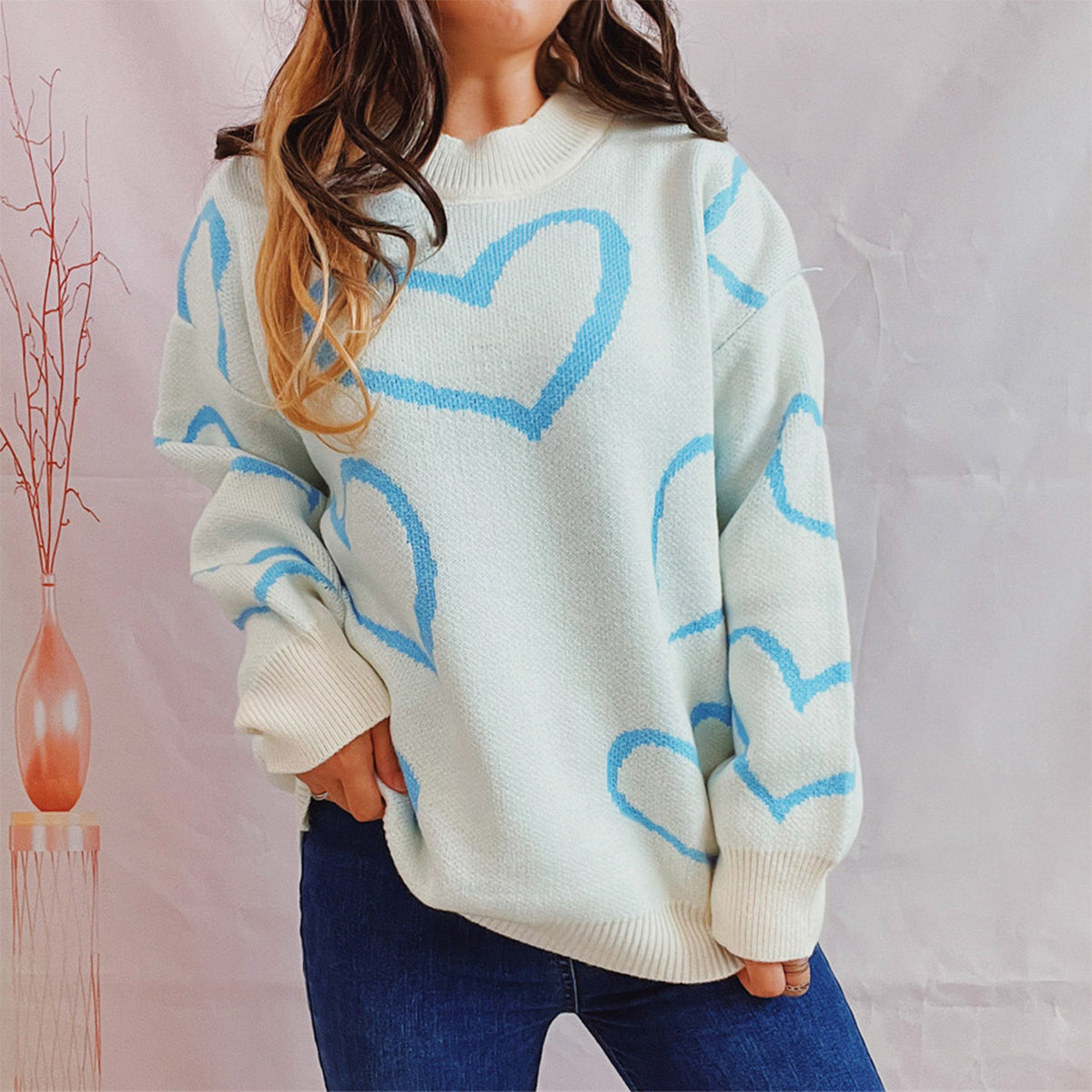 Pastel blue heart outline knit sweater with crewneck and long sleeves.