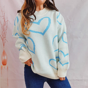Pastel blue heart outline knit sweater with crewneck and long sleeves.