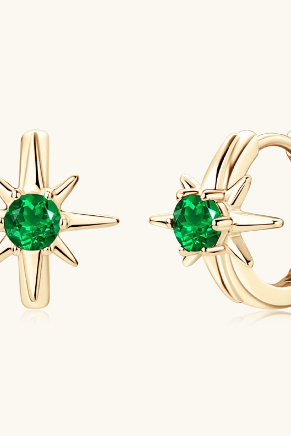 Gold starburst hoop earrings with emerald green center stones