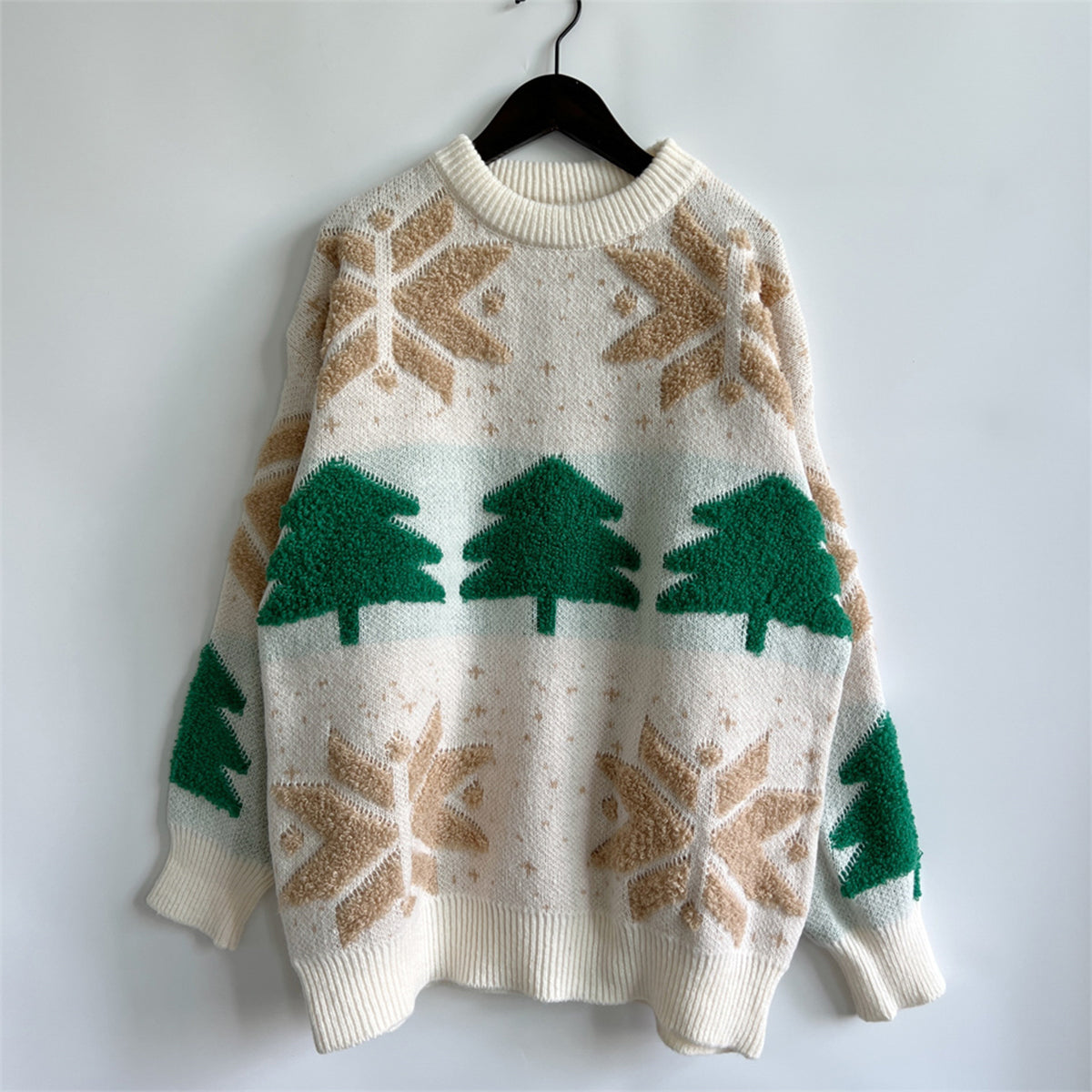 Cream knit sweater with green Christmas trees and tan snowflake appliqués.