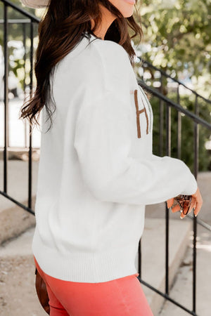 White drop shoulder sweater with brown embroidered "H" detail, ribbed cuffs and hem.
