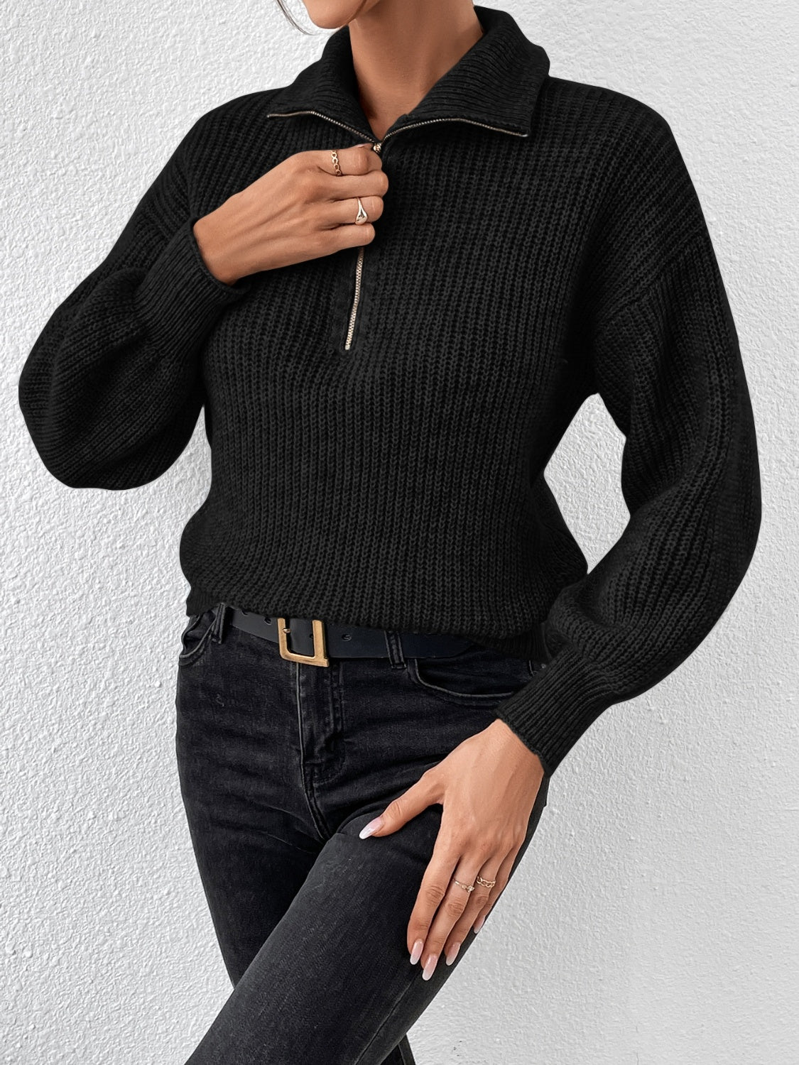 Black ribbed zip-up sweater with a collared neckline and balloon sleeves.