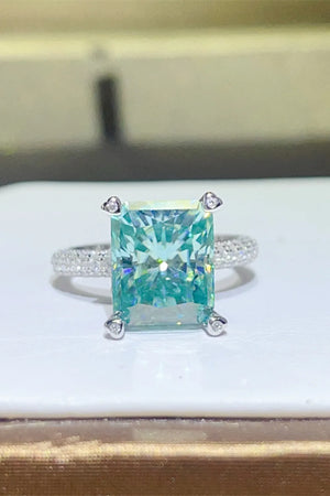 Teal radiant cut emerald ring with pave band and diamond prongs