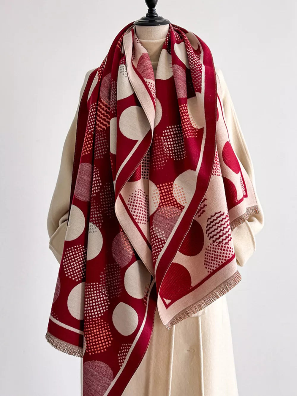 Deep red and cream polka dot textured scarf with fringe detail.