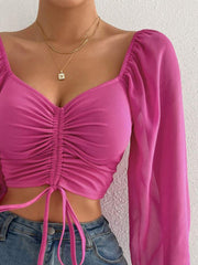Pink ruched bodice crop top with puff sleeves and tie detail