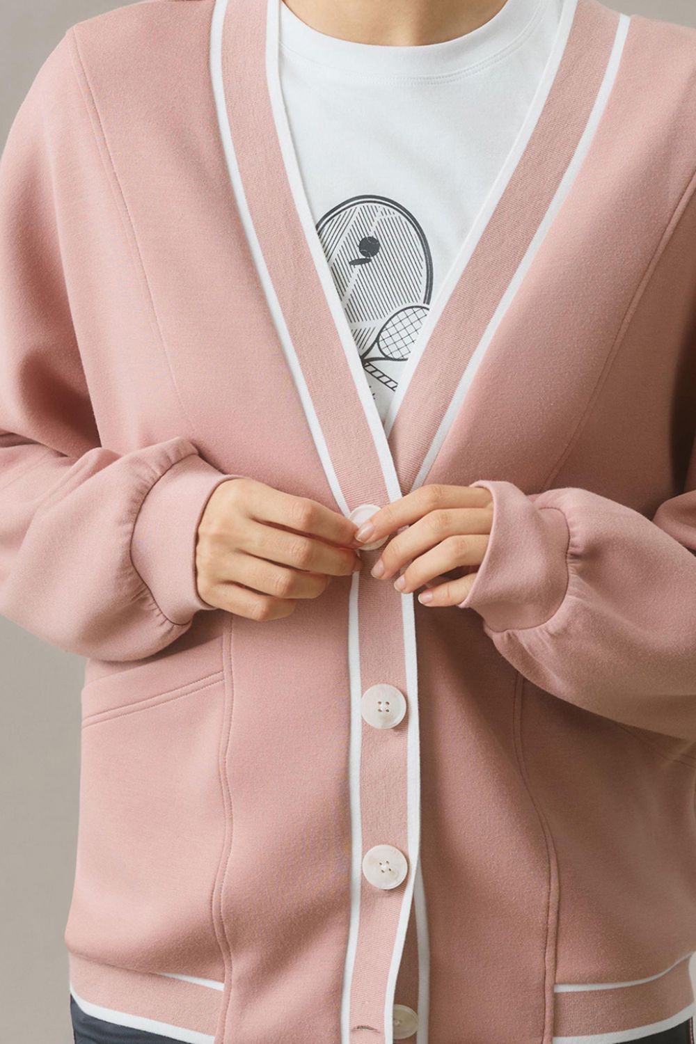 Dusty pink cocoon cardigan with white varsity trim and button closure.