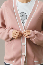 Dusty pink cocoon cardigan with white varsity trim and button closure.