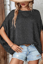 Black dot print batwing sleeve blouse with split sleeves and a round neckline.