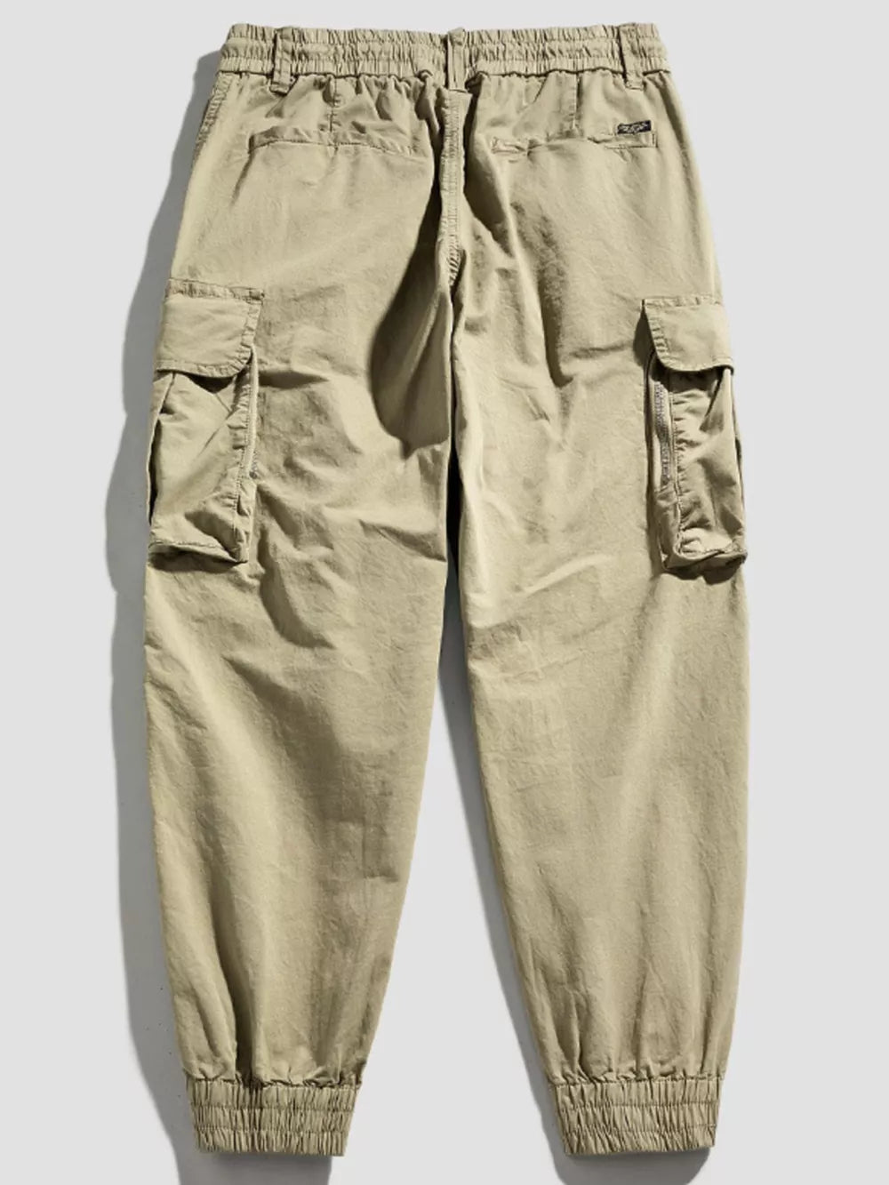 Khaki cargo joggers with flap pockets and elastic cuffs.